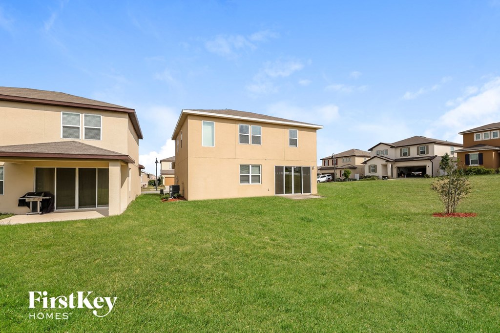a group of houses on a green lawn with a blue sky