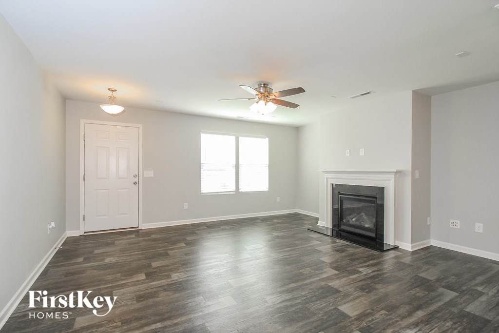 a living room with a fireplace and a ceiling fan