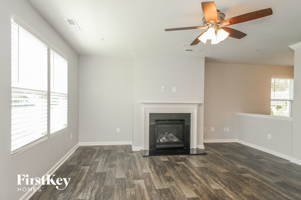 a living room with a fireplace and a ceiling fan