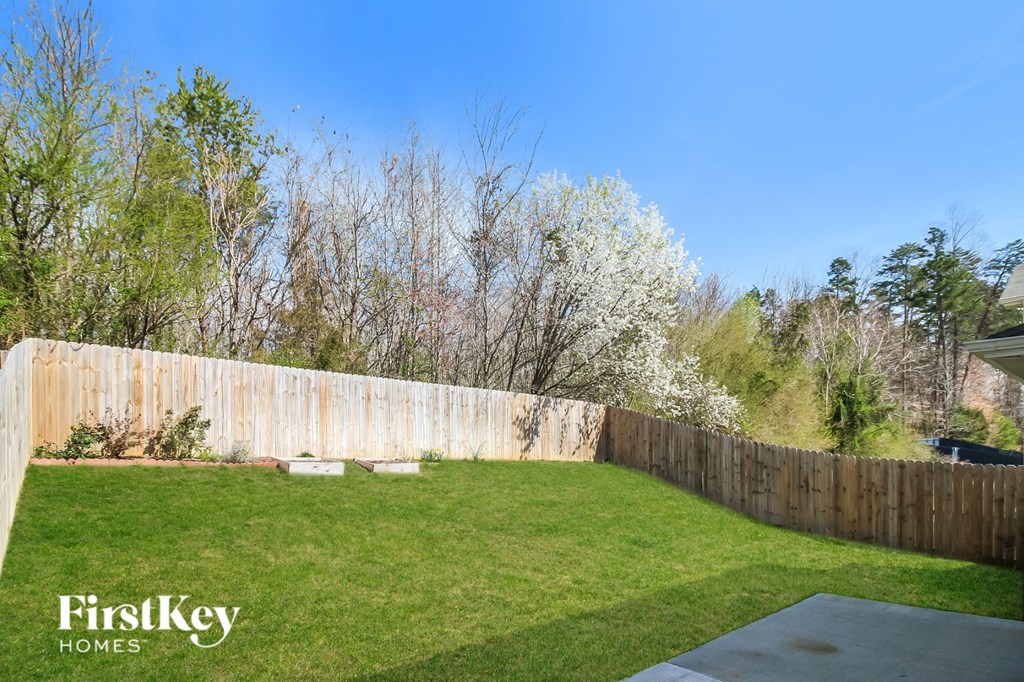 a backyard with a wooden fence and green grass