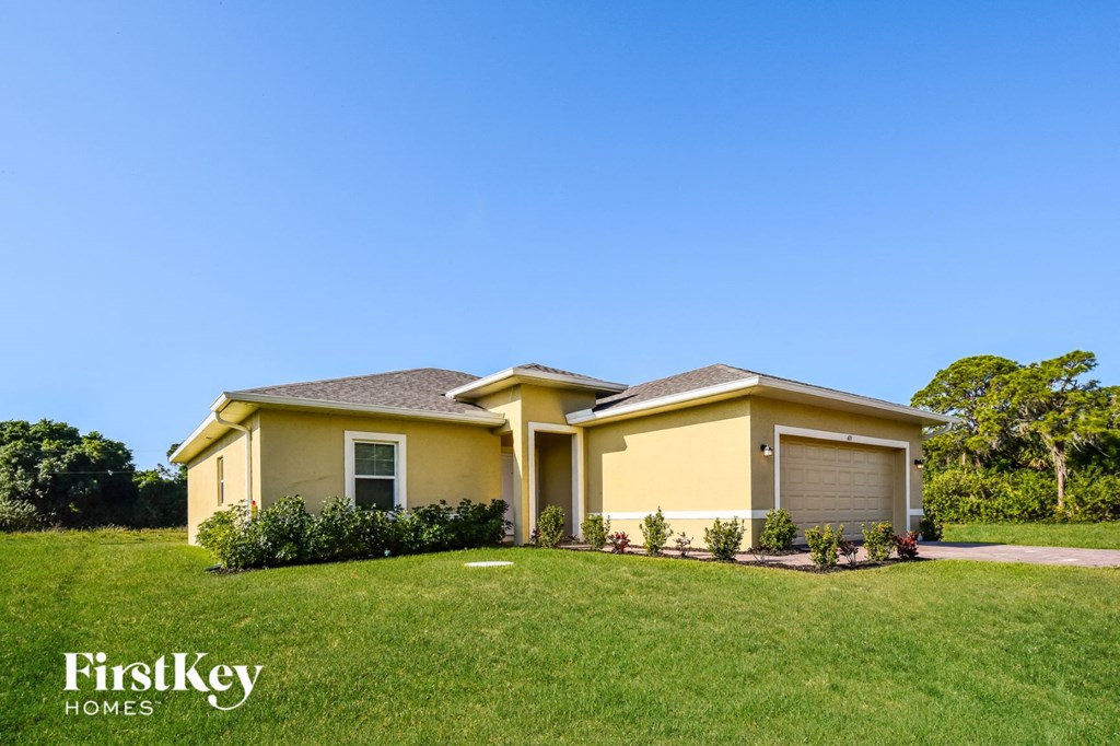 A yellow house with a garage door is for sale by FirstKey Homes.