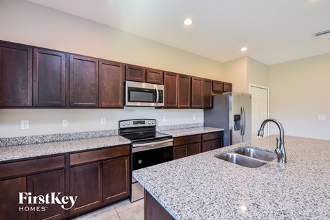 A kitchen with brown cabinets and a granite countertop.