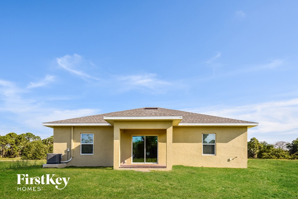 A house with a brown roof and a yellow exterior is for sale.