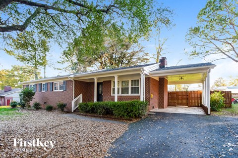 a brick house with a covered porch and a driveway