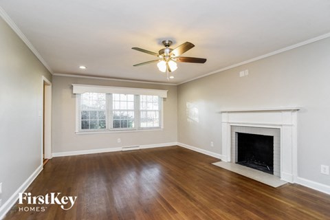 a living room with a fireplace and a ceiling fan