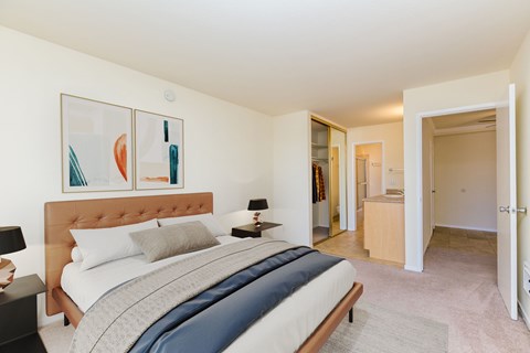 A bedroom with a large bed and a painting on the wall.