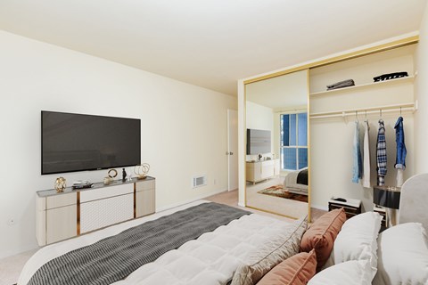 A bedroom with a large bed and a flat screen TV.