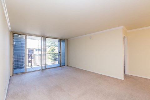 Empty room with sliding glass doors leading to a balcony.