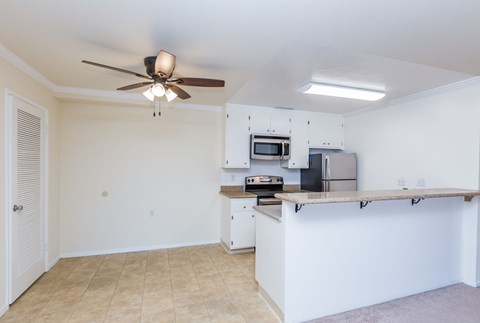 A kitchen with a fan on the ceiling and a countertop.