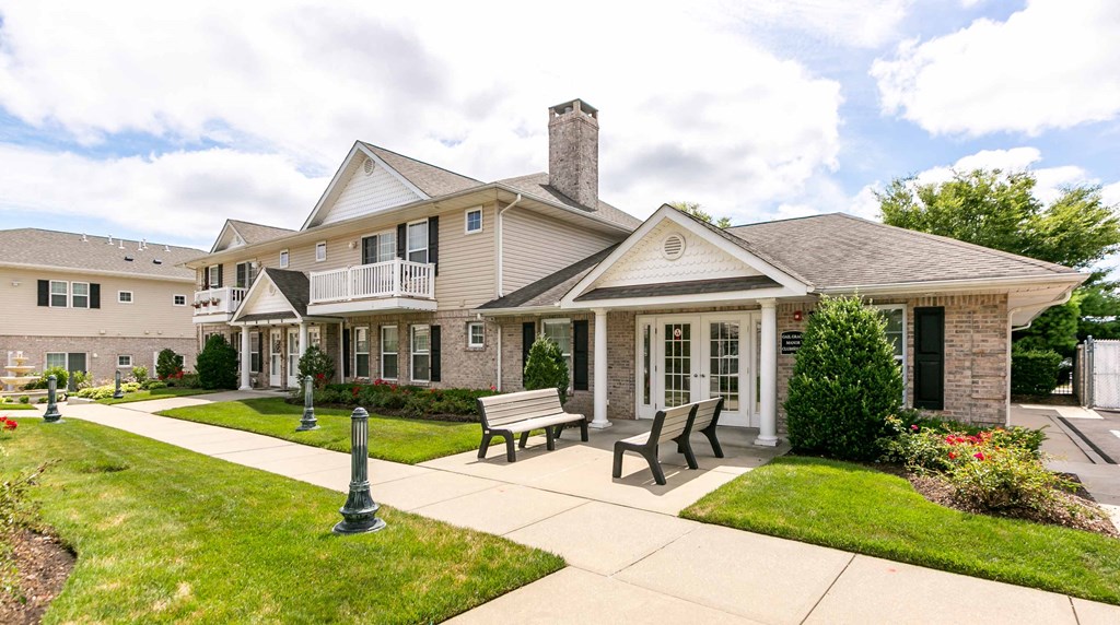 the front of a house with a patio and benches