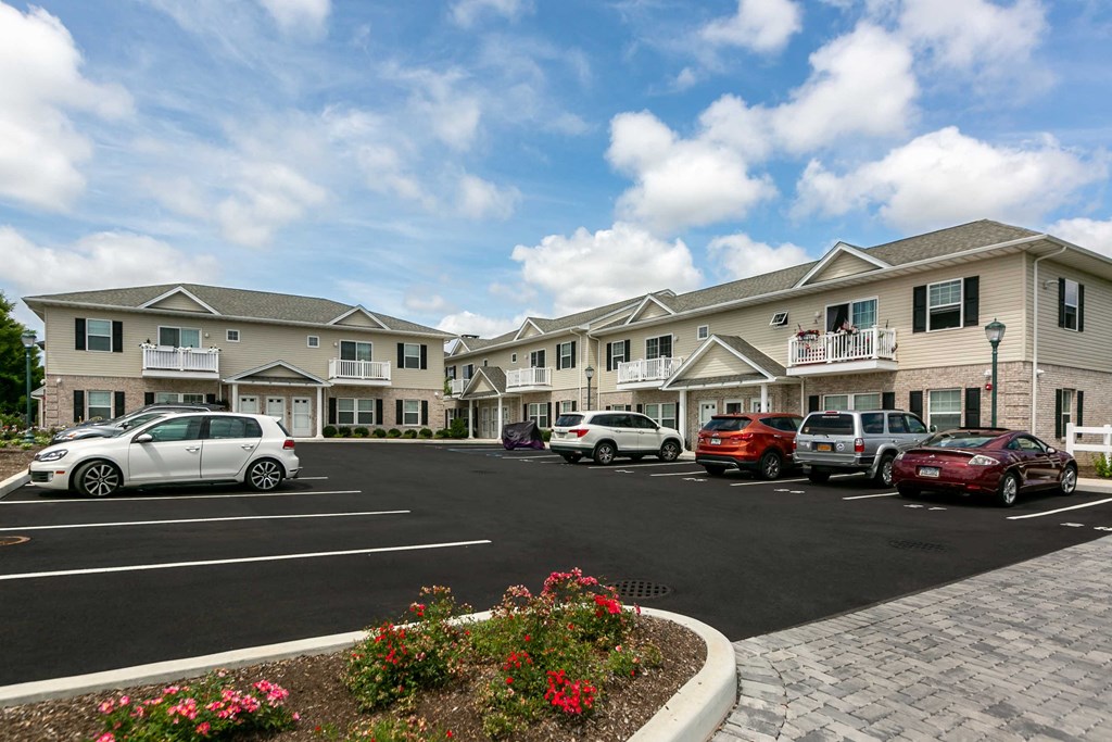a parking lot filled with cars in front of buildings