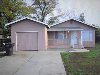 a pink house with a driveway and a garage door