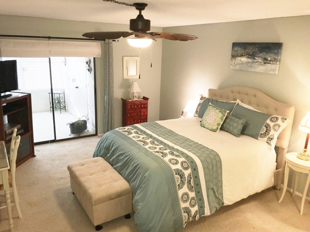a bedroom with a large bed and a ceiling fan
