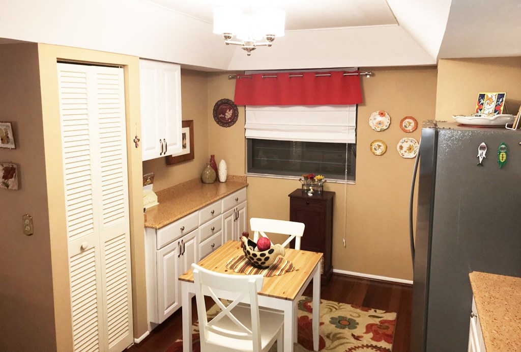 a small kitchen with a table and a refrigerator