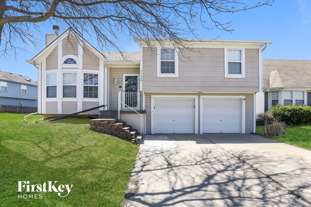 a white house with two garage doors and a driveway