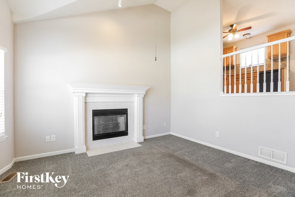 a living room with a fireplace and a ceiling fan
