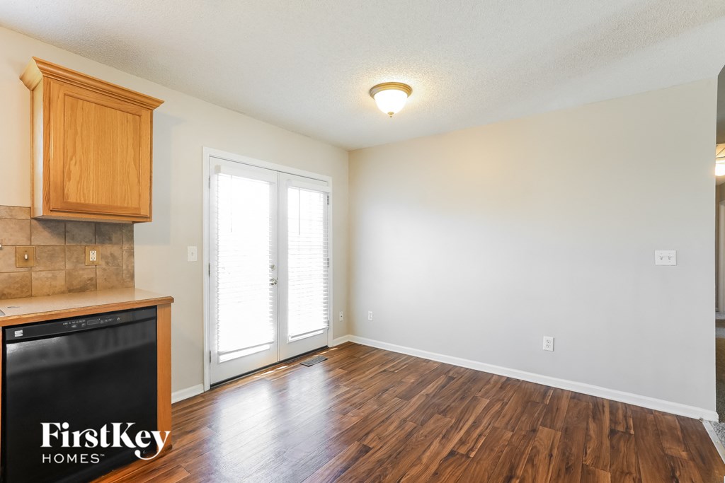a kitchen and living room with wood flooring and a door to a balcony