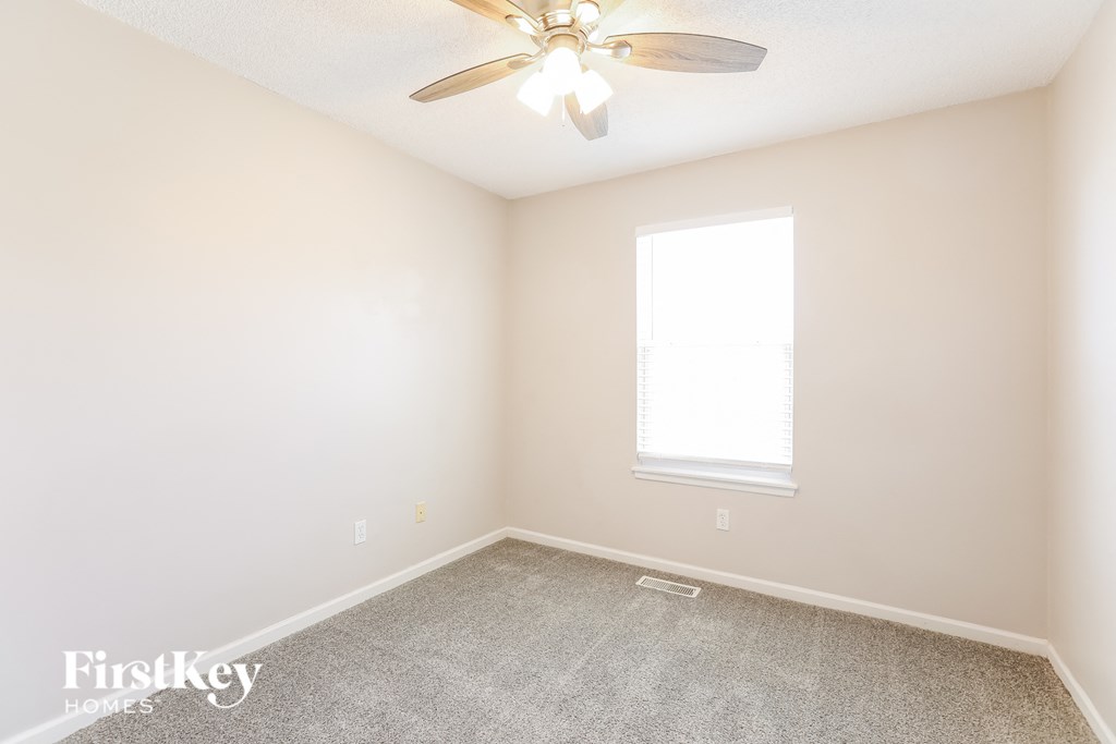 a bedroom with a ceiling fan and a window