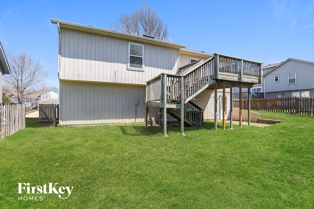 a home with a deck and a staircase in a yard