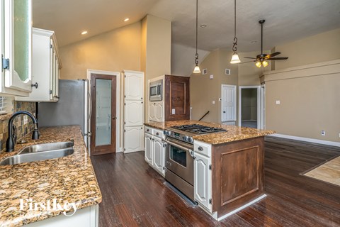 a kitchen with white cabinets and granite counter tops