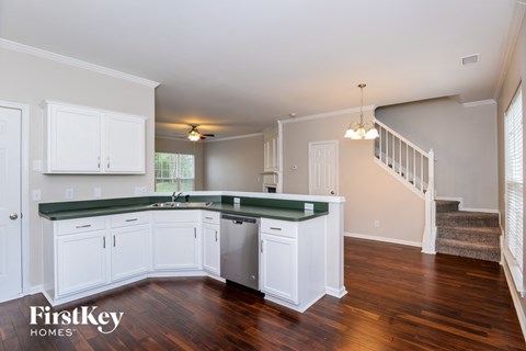 A kitchen with white cabinets and a green countertop.