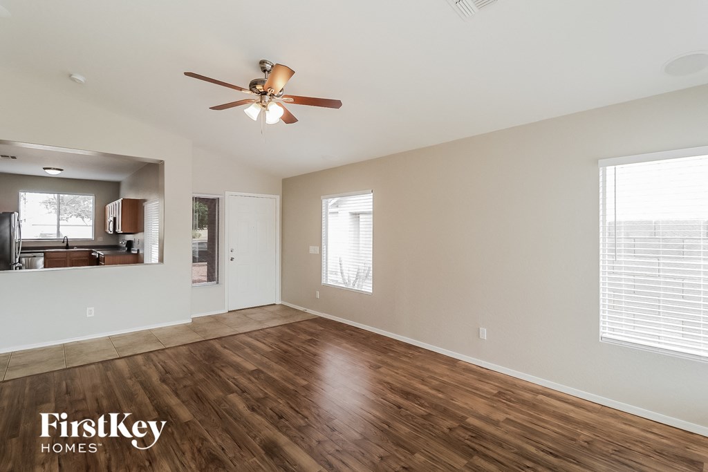 A room with a ceiling fan and wooden flooring.