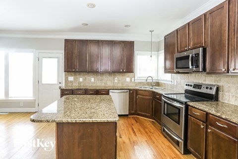 a kitchen with wooden cabinets and granite counter tops
