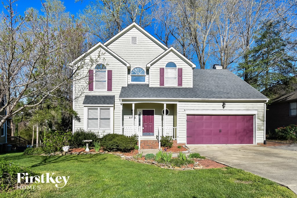 a white house with a pink garage door