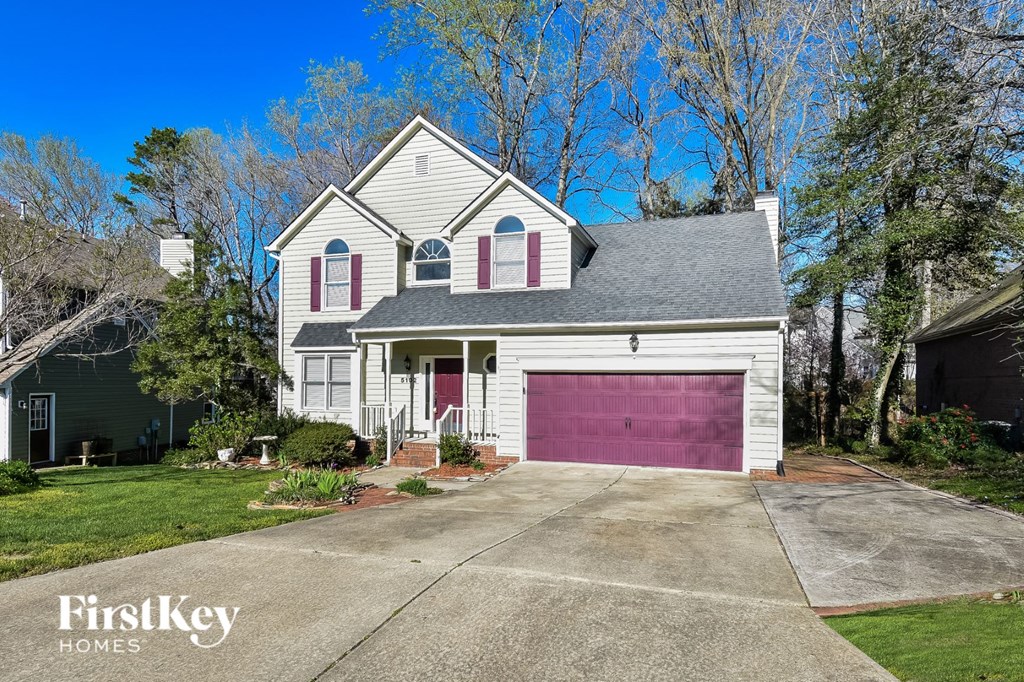 a white house with a pink garage door
