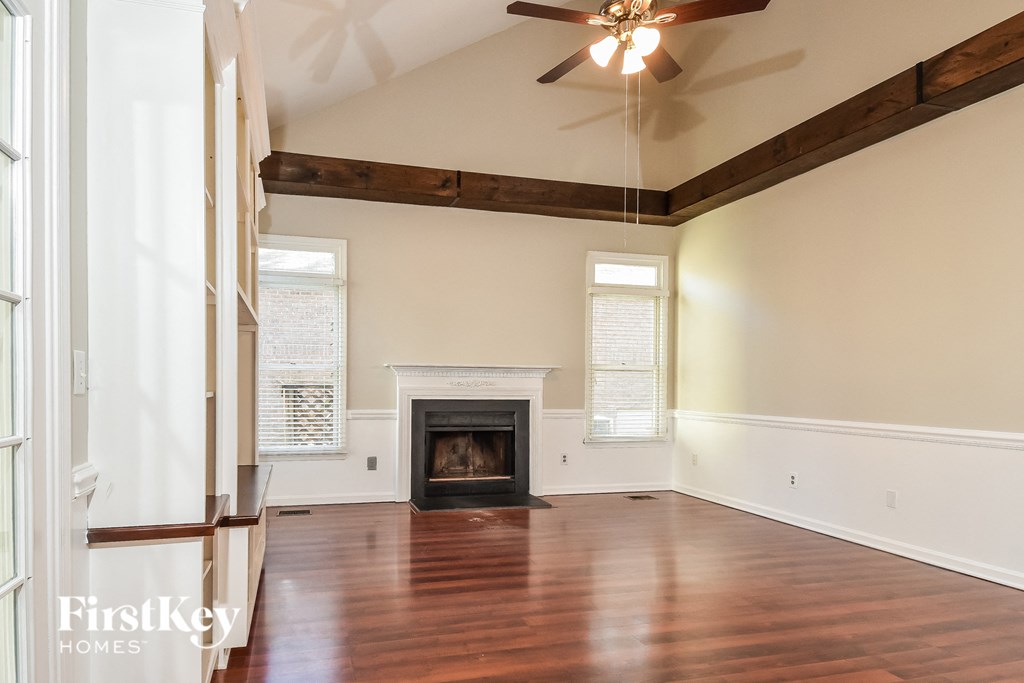 an empty living room with wood floors and a fireplace