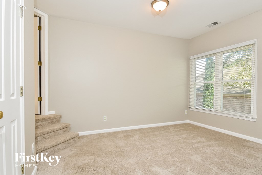 a living room with carpeted stairs and a large window