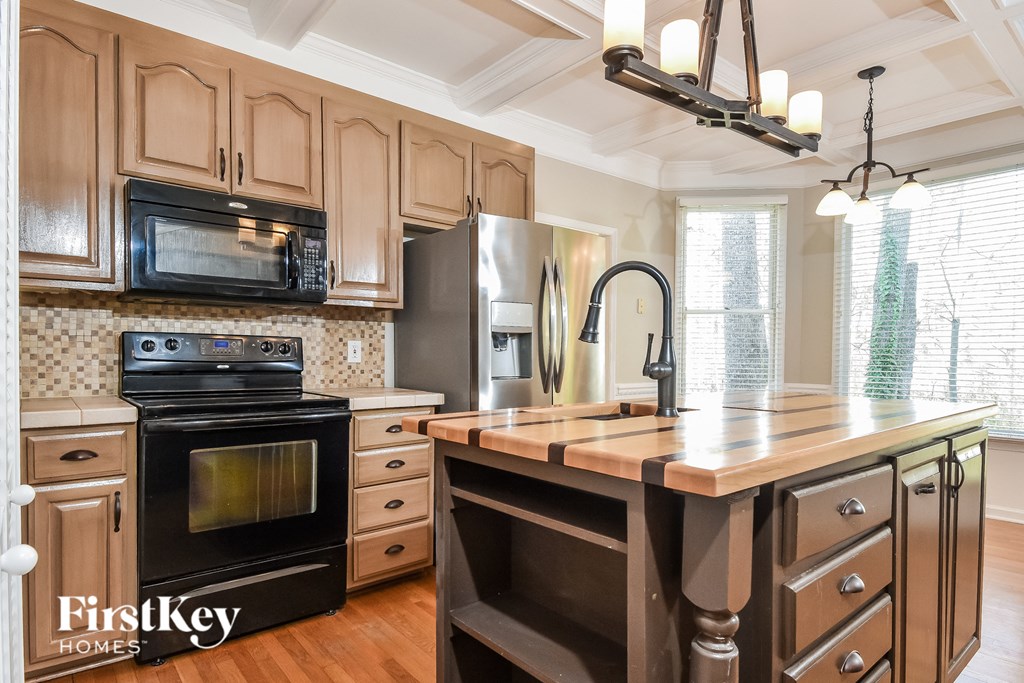 a kitchen with a large island and stainless steel appliances