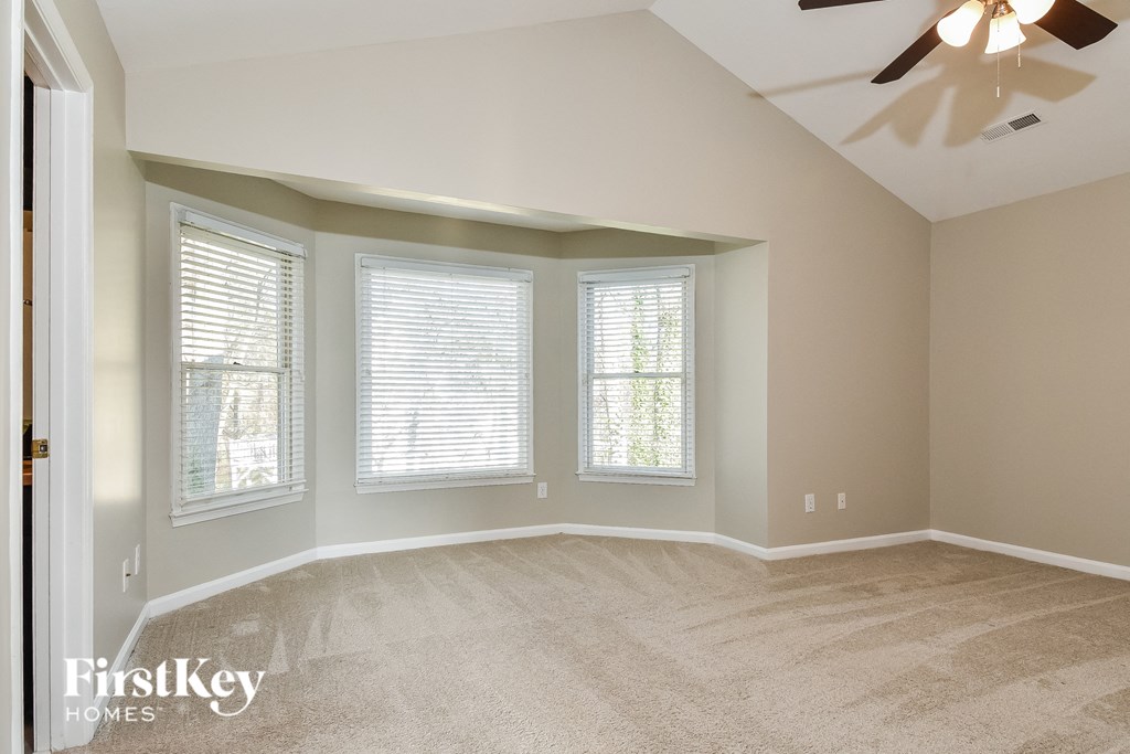 the second bedroom is spacious and has a ceiling fan and three windows