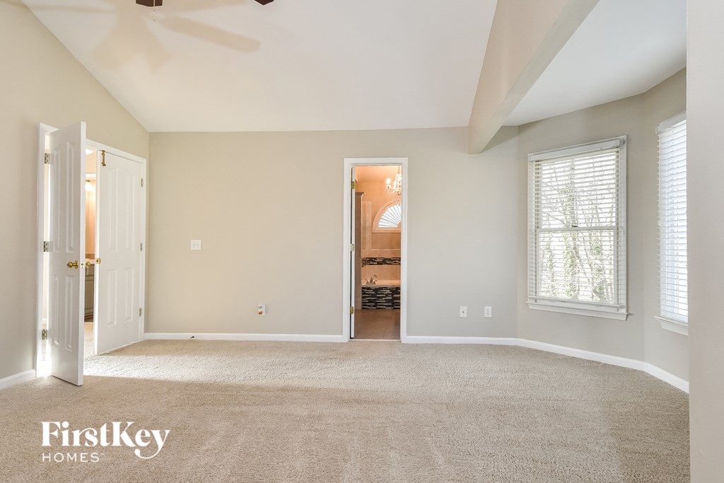a living room with a carpeted floor and a door to a hallway