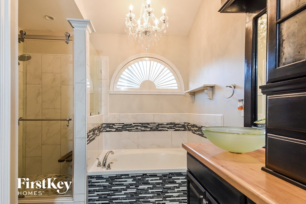 a bathroom with a tub and a sink and a window