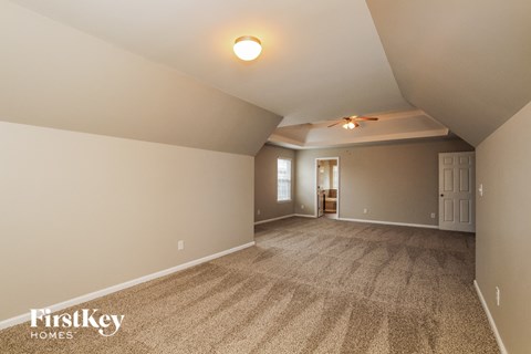 a living room with carpet and a ceiling fan