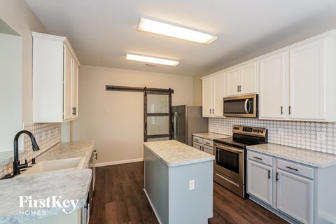 a kitchen with white cabinets and stainless steel appliances