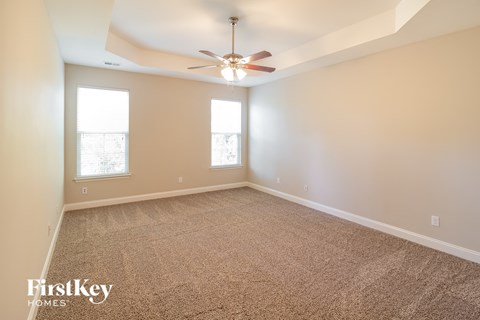 a living room with carpet and a ceiling fan