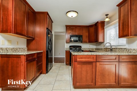 A kitchen with wooden cabinets and a granite countertop.