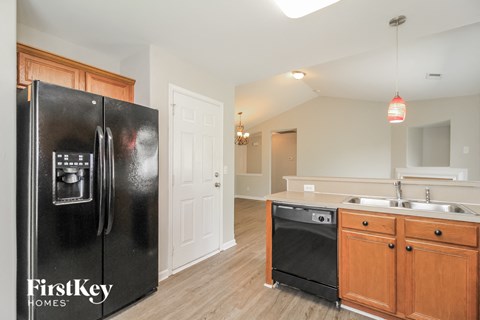 a kitchen with a refrigerator and a sink and a door