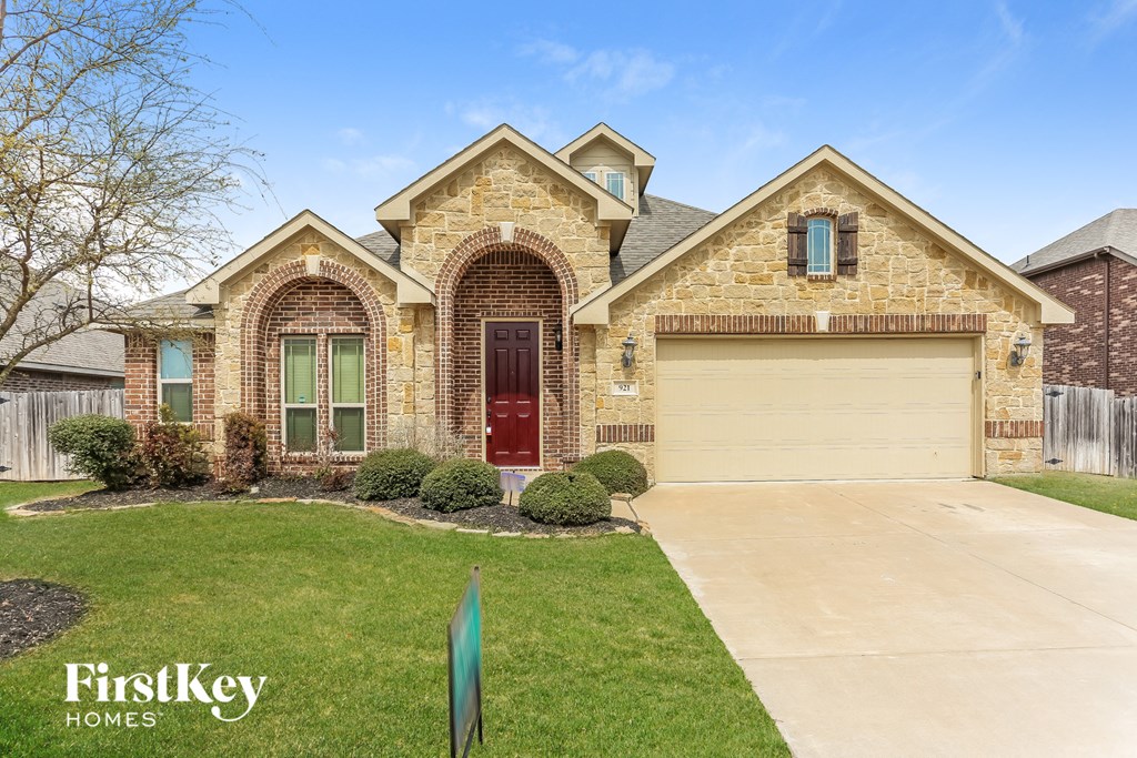 A house with a red door and a garage door is for sale.