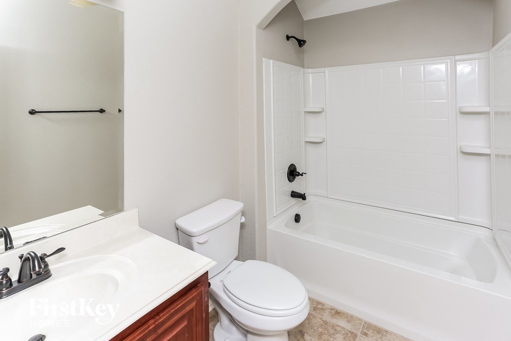 A white bathroom with a toilet, sink, and bathtub.