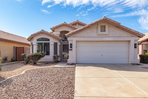 A house with a white garage door and a brown roof.