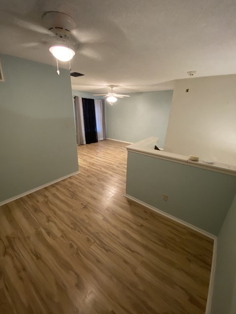 A room with wooden flooring and a white ceiling.