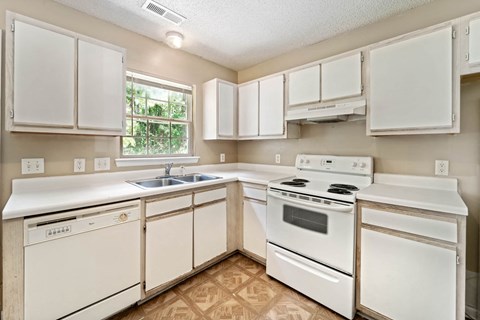 A kitchen with white appliances and cabinets.