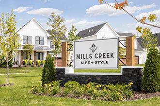 the sign for mills creek life style in front of a house