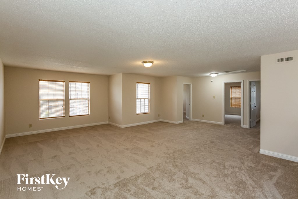 the living room and dining room of an empty house