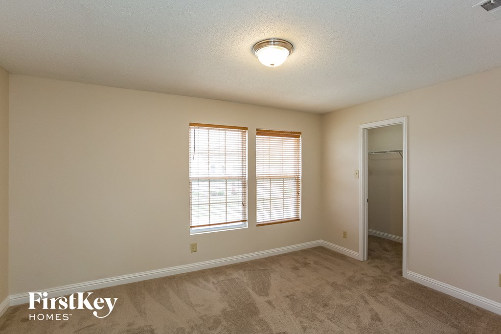 the living room of a house with two windows and a door