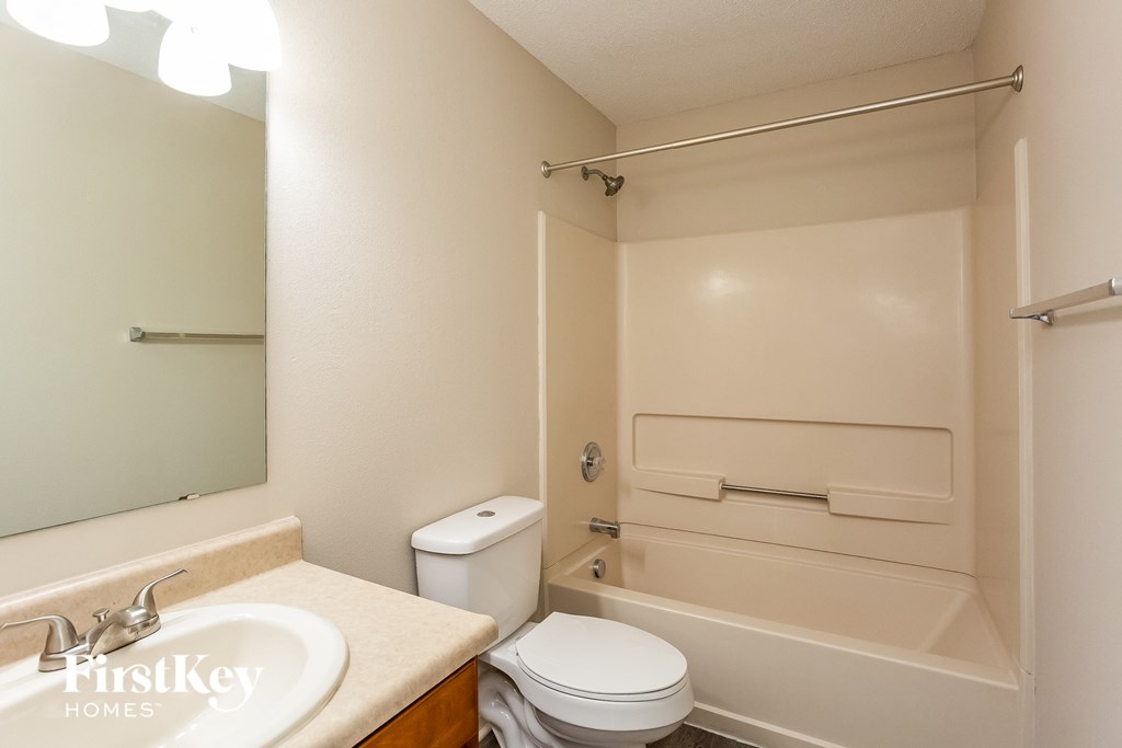 a bathroom with a toilet and a tub and a sink