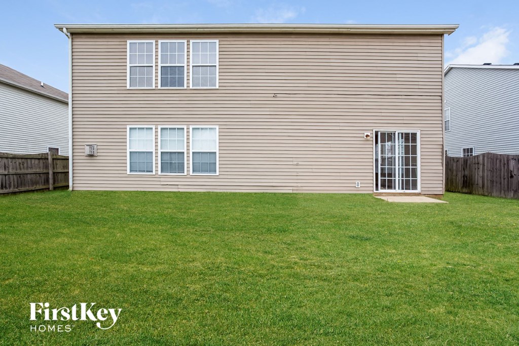 a home with a yard in front of it and a wooden fence